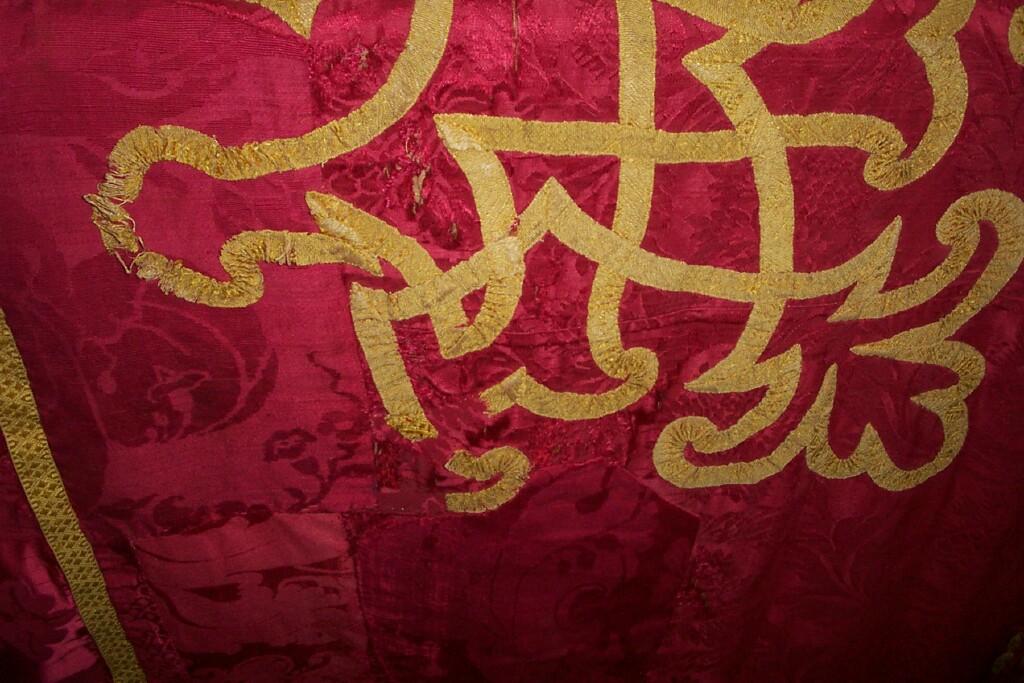 Appraisal: A large dark pink Damask shaped panel with appliqued gold