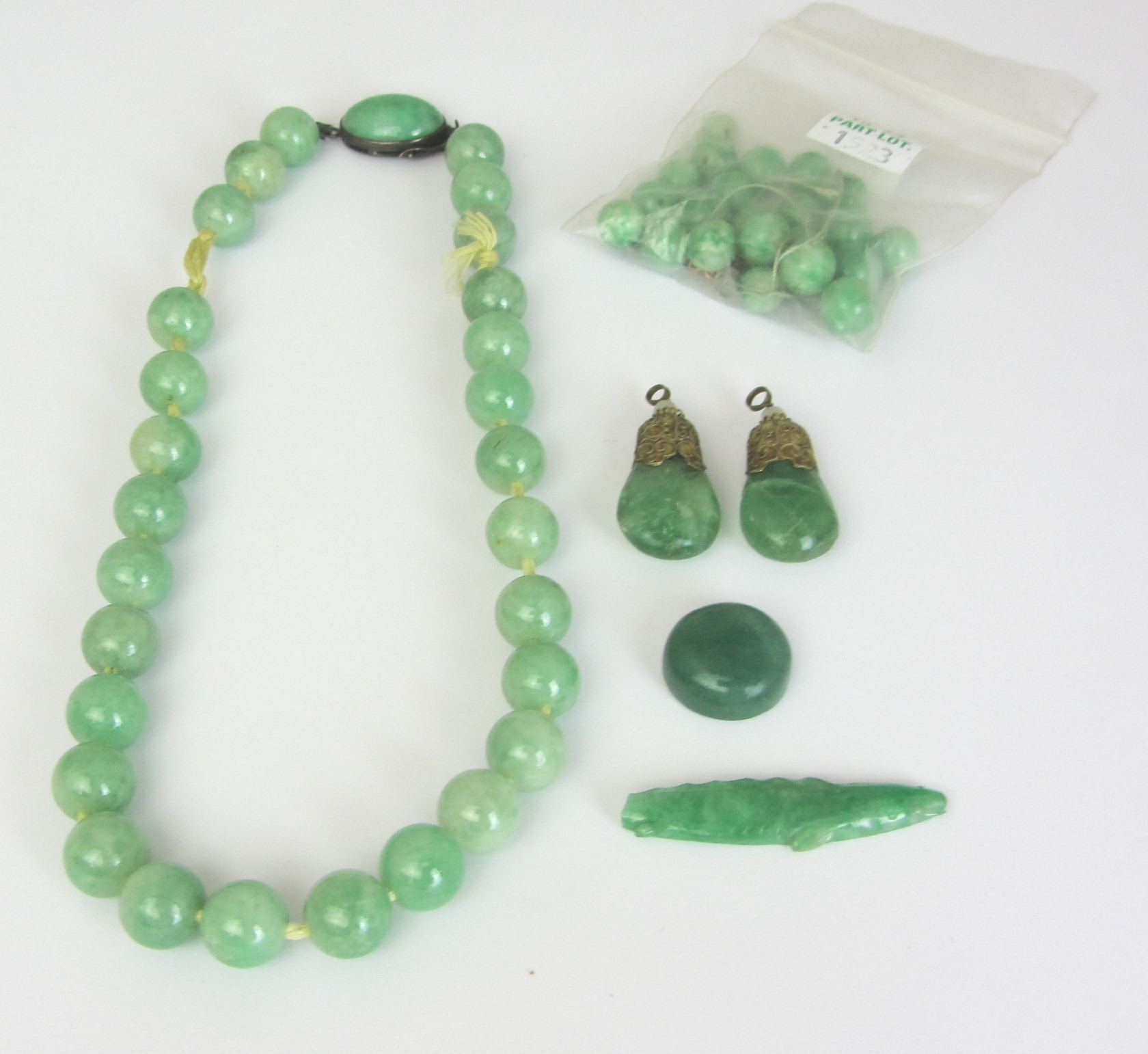 Appraisal: A single row necklace of jade beads on an oval