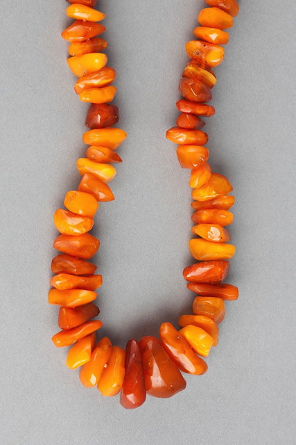 Appraisal: A GRADUATE AMBER BEAD NECKLACE with uncut beads cm long