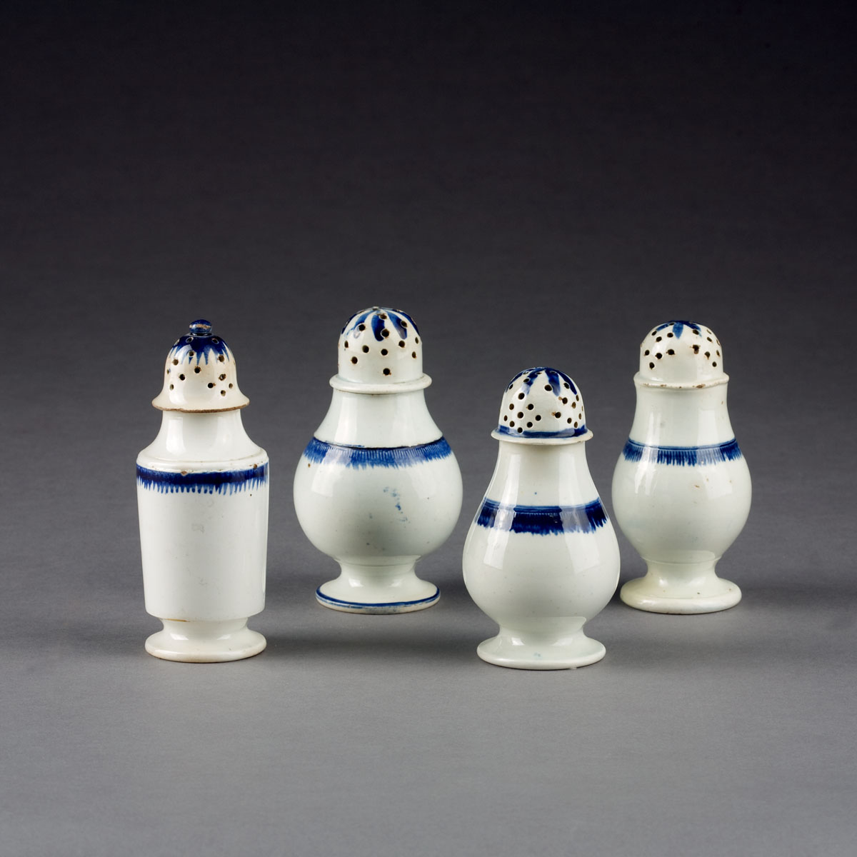 Appraisal: FOUR ENGLISH BLUE SHELL-EDGE PEPPERPOTS