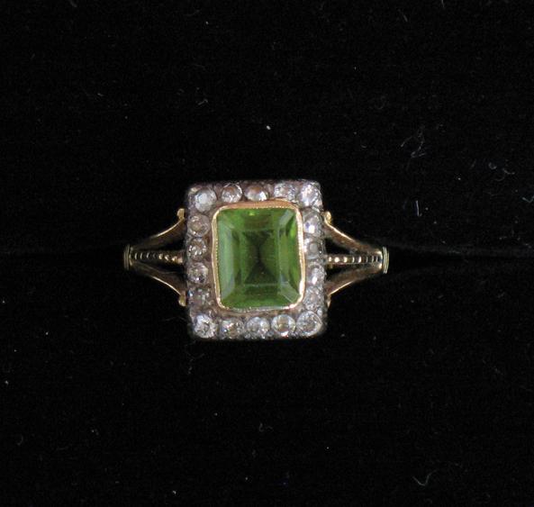 Appraisal: AN EDWARDIAN PERIDOT AND DIAMOND CLUSTER RING the central square-cut