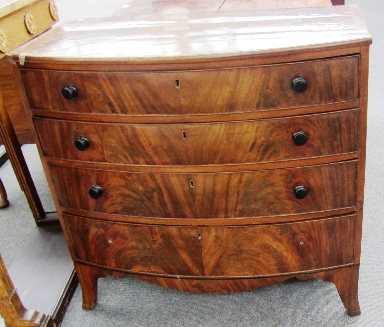 Appraisal: A George III mahogany bowfront chest of four long graduated