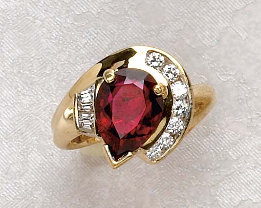 Appraisal: GARNET AND DIAMOND RING k yellow gold ring set with