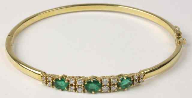 Appraisal: An emerald and diamond set ct yellow gold bangle three