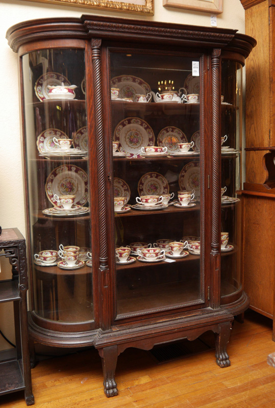 Appraisal: LARGE OAK TRIPLE BOWFRONT CABINET Carved pediment glass front door