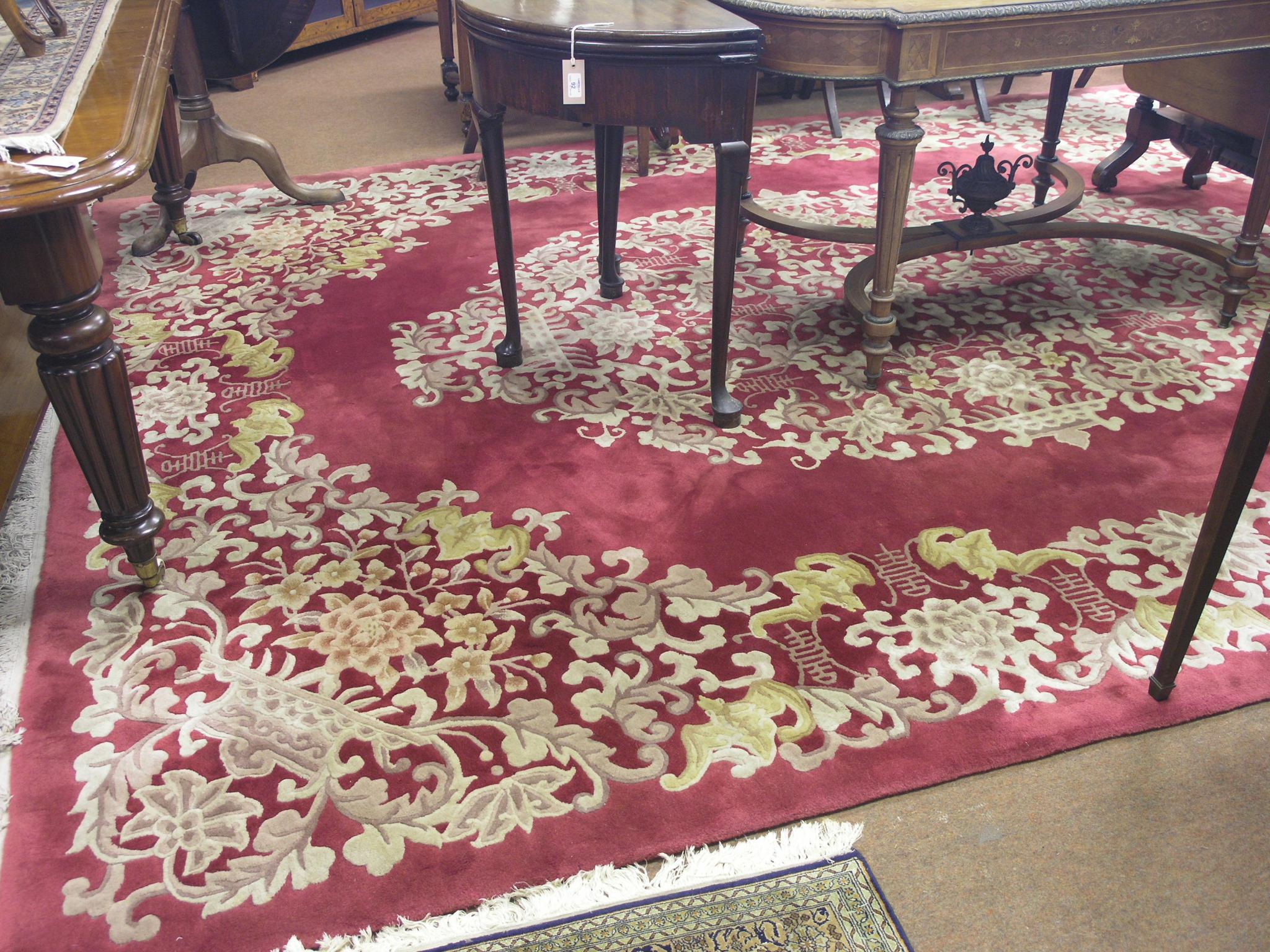 Appraisal: A large Chinese rug bright floral designs against a burgundy