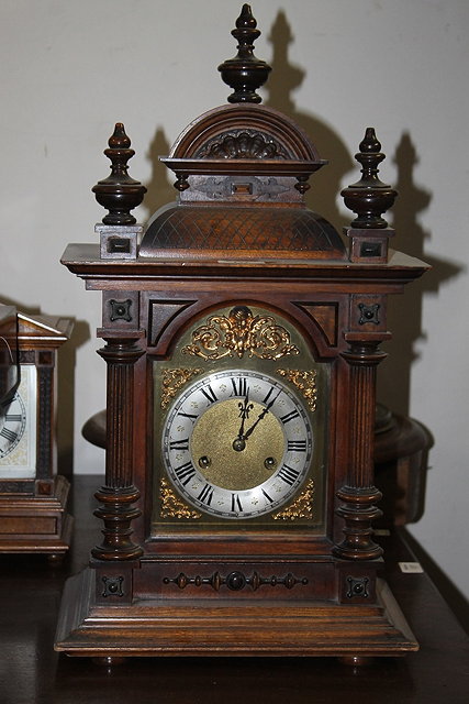 Appraisal: A GERMAN WALNUT MANTEL CLOCK with arched gilt and silvered