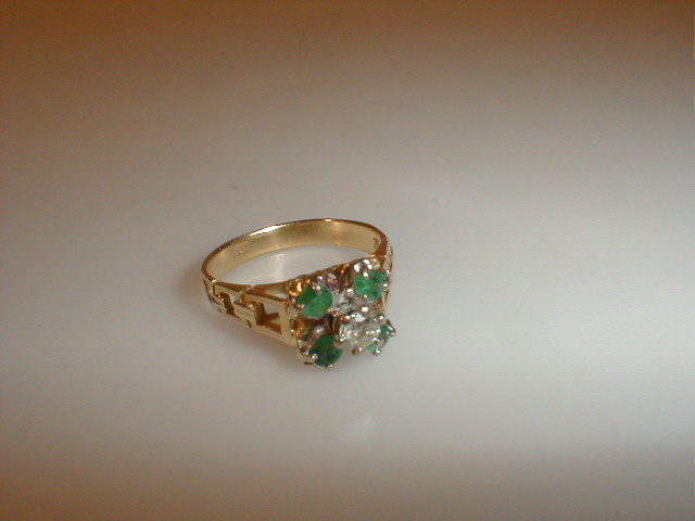 Appraisal: An emerald and diamond high set cluster ring the central