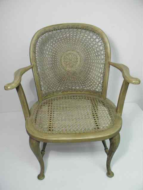 Appraisal: A painted wood and rattan armchair Carved frame painted with