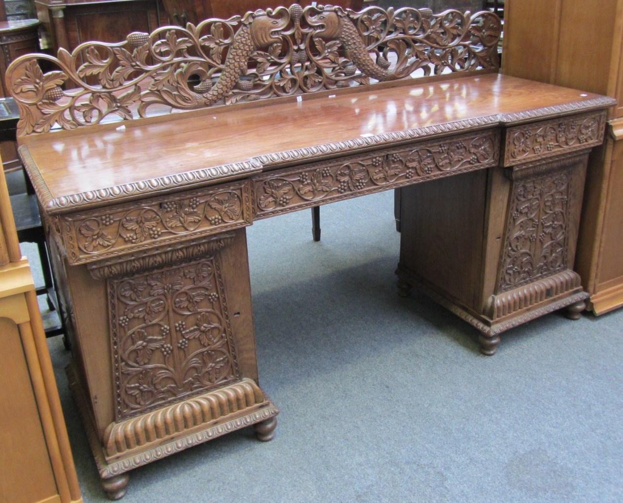 Appraisal: An Anglo Indian hardwood pedestal sideboard the ledge back carved