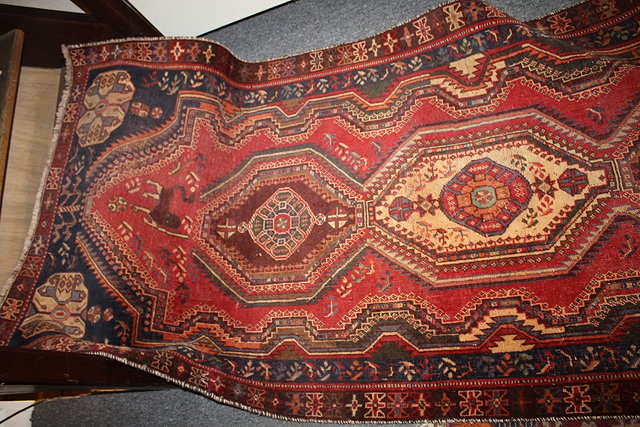 Appraisal: AN AFGHAN RED GROUND WOOL RUNNER with stylised animal flower