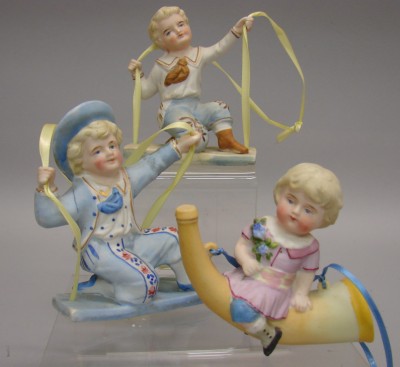 Appraisal: -Bisque Swing figurines Pair of boys kneeling on swings Is