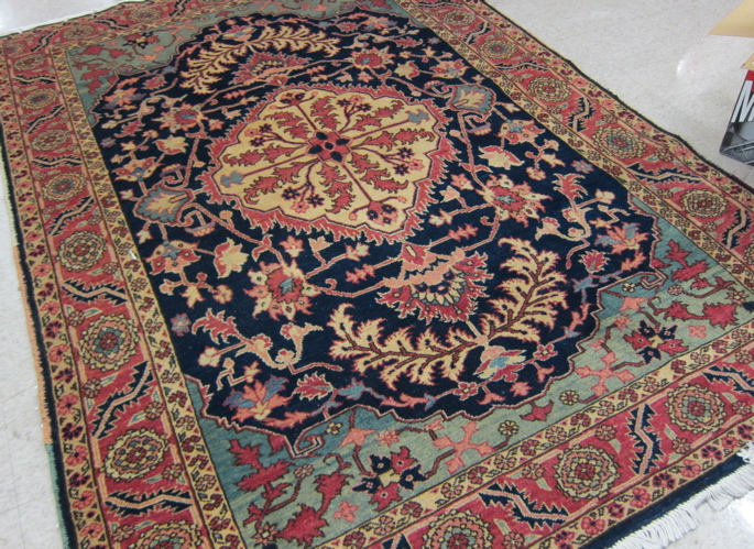 Appraisal: HAND KNOTTED ORIENTAL AREA RUG Persian Serapi design central flower-filled