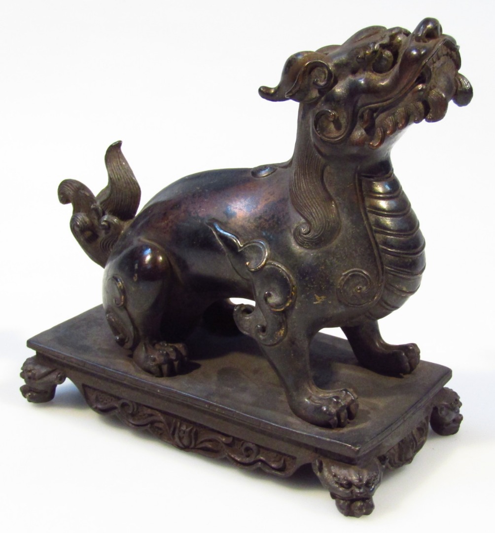 Appraisal: A Chinese figure group of a standing bronze dragon on