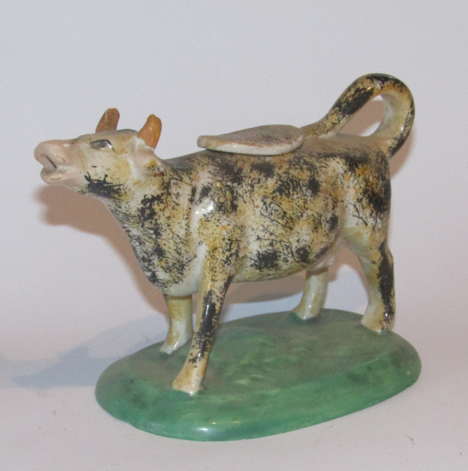 Appraisal: A thC Staffordshire cow creamer with entwined tail and lid