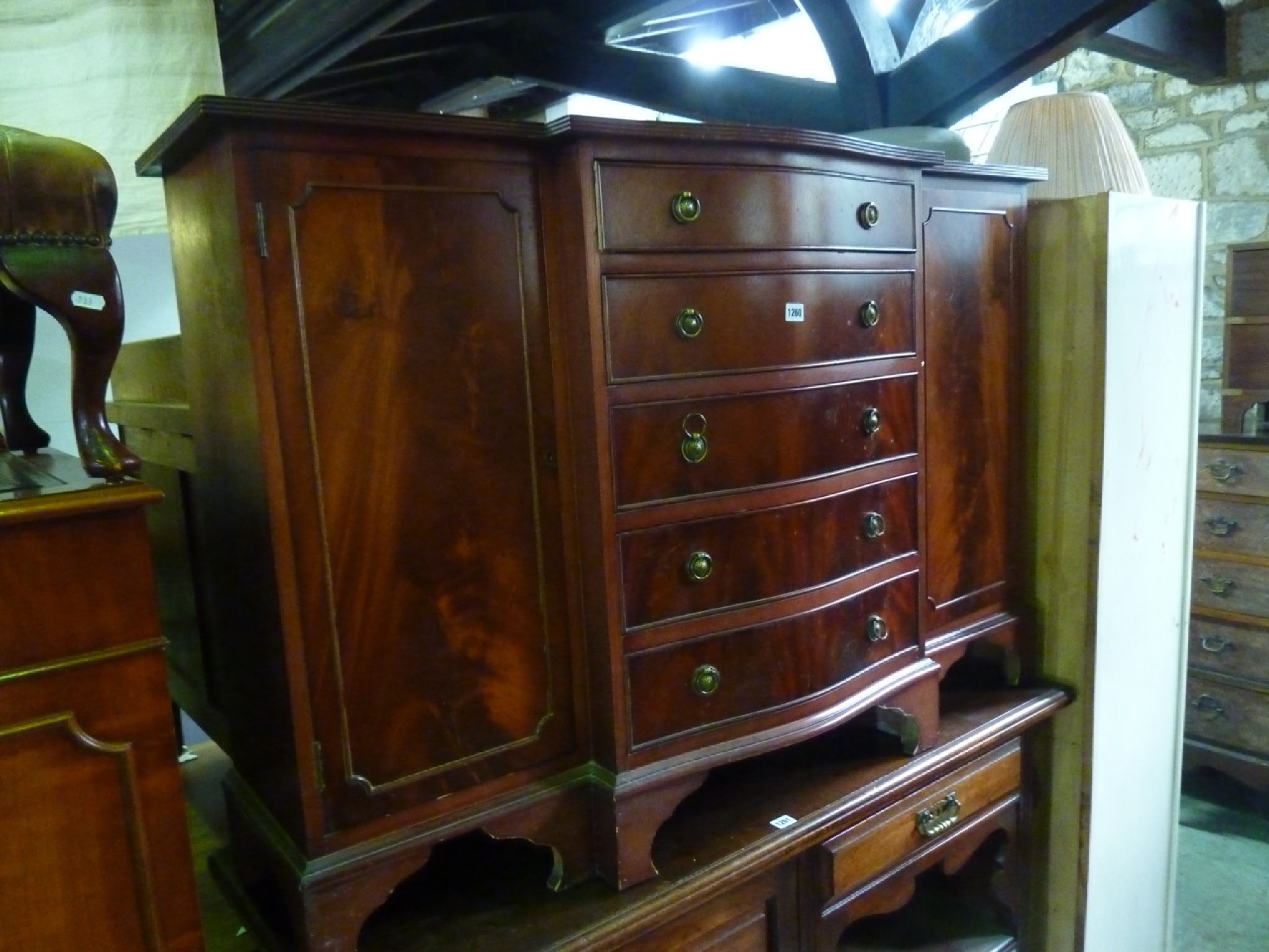 Appraisal: A reproduction mahogany breakfront side cupboard partially enclosed by a