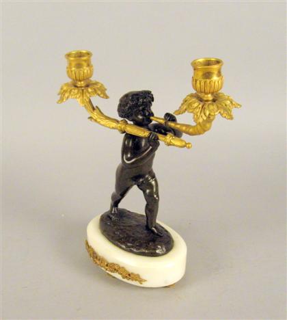 Appraisal: French gilt and patinated metal figural candelabrum The central patinated