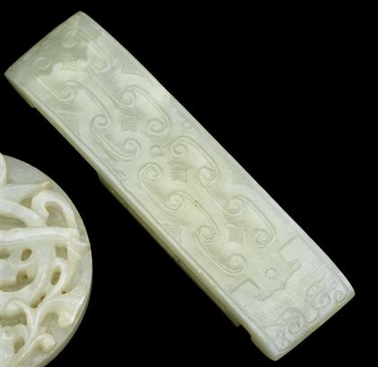 Appraisal: Chinese light celadon jade fittingElongated rounded rectangular form archaic scrolls