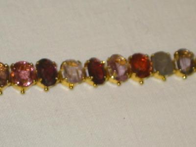 Appraisal: A GARNET BRACELET comprising various coloured oval cut garnets claw