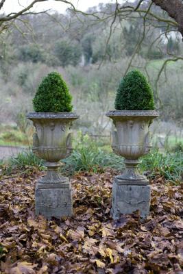 Appraisal: A pair of campana urns with Bacchic mask handles on