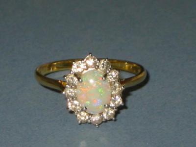 Appraisal: AN OPAL AND DIAMOND CLUSTER RING the cabochon oval claw