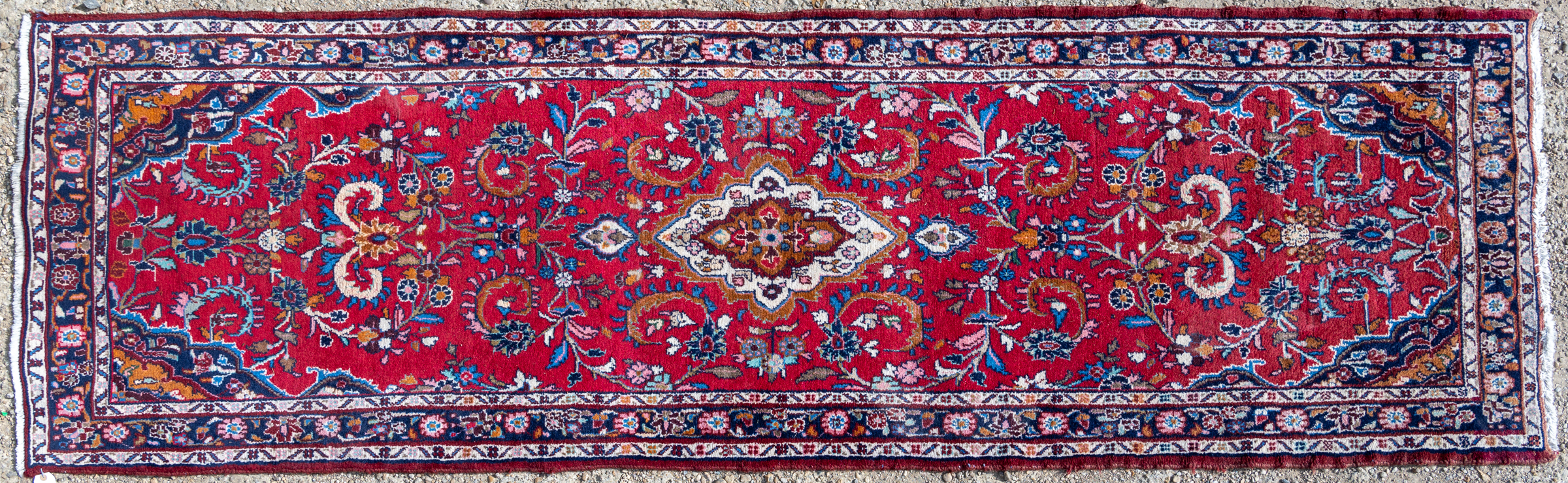 Appraisal: An Oriental red ground runner with floral scrolls within a