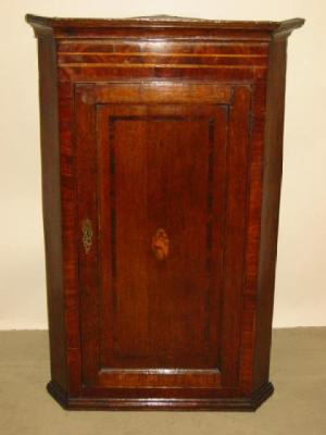 Appraisal: A GEORGE III OAK CORNER CUPBOARD with mahogany crossbanding stringing