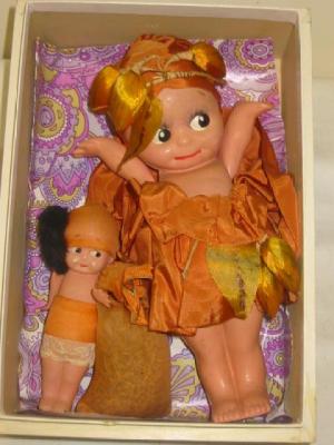 Appraisal: Two Japanese Kewpie dolls with painted faces in orange silk