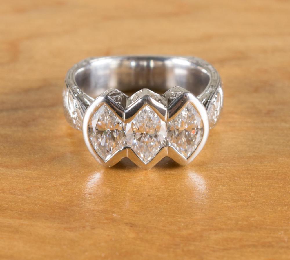 Appraisal: DIAMOND AND PLATINUM THREE-STONE RING The heavy engraved platinum ring