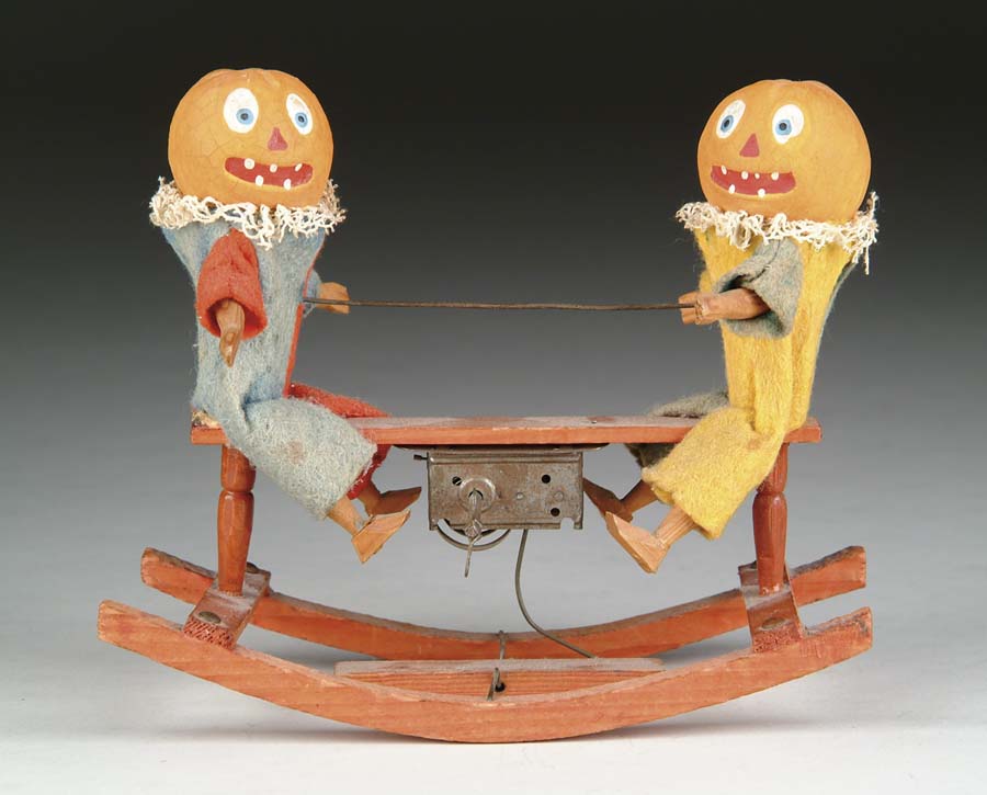 Appraisal: PUMPKINS ON MECHANICAL SEESAW Carved wood bodies cloth dressed with