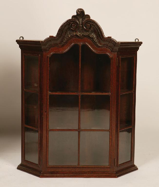 Appraisal: A CONTINENTAL HANGING OAK DISPLAY CABINET the arched top with