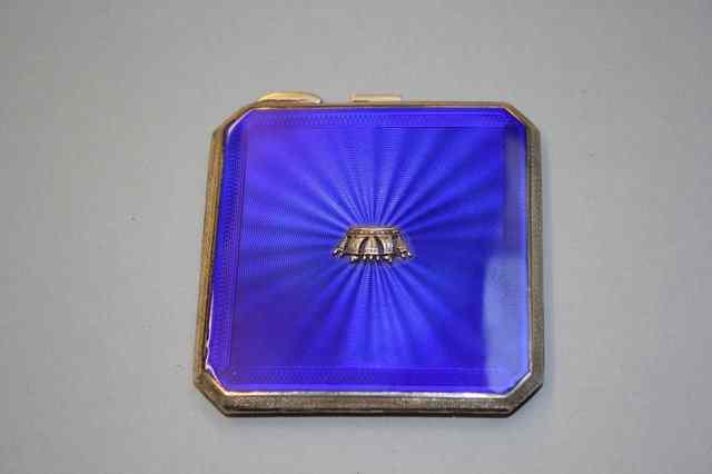 Appraisal: A SILVER AND ENAMELLED COMPACT blue enamel lid with sun