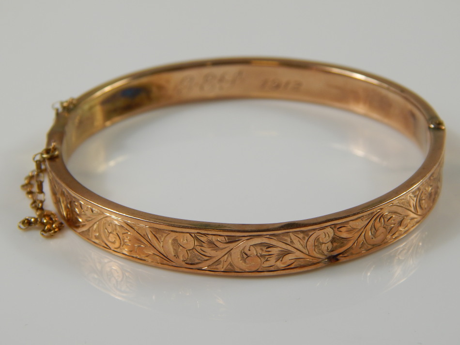 Appraisal: A ct gold hinged bangle florally engraved AF with initials