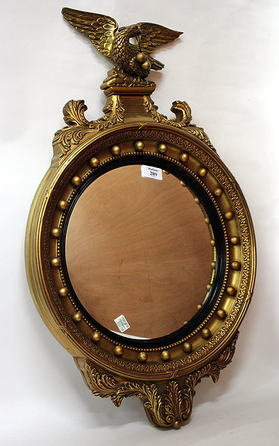 Appraisal: A GILT FRAMED CONVEX WALL MIRROR with eagle crest cm