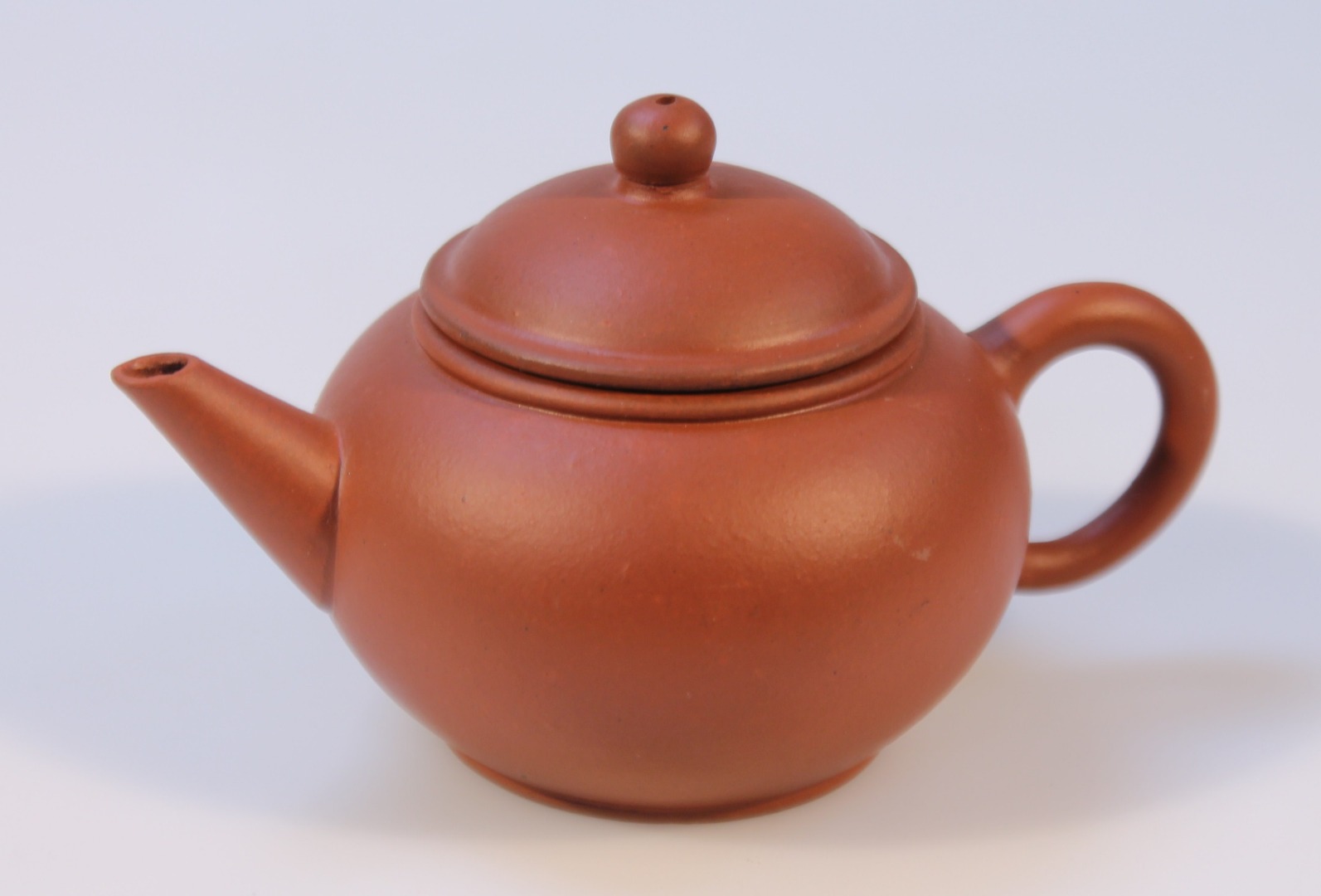 Appraisal: A Chinese redware pottery teapot the domed cover with orb