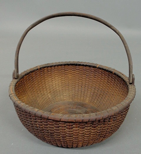 Appraisal: Nantucket basket with swing handle and concentric circle wood base