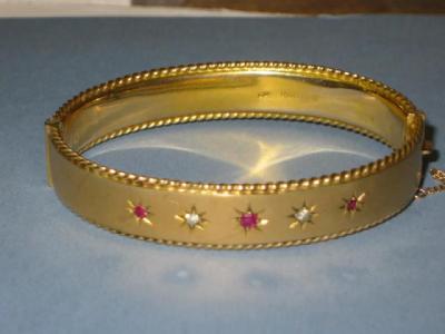 Appraisal: A CT GOLD RUBY AND DIAMOND BANGLE the hinged top