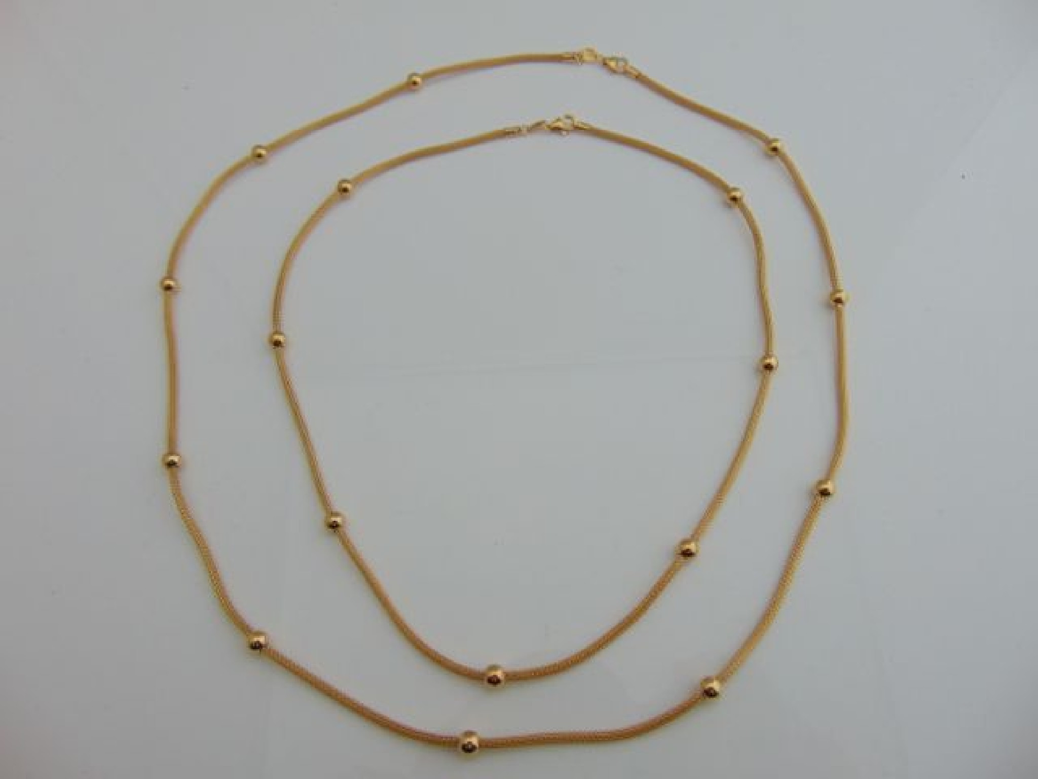 Appraisal: Two ct gold necklaces each woven strand highlighted with ball