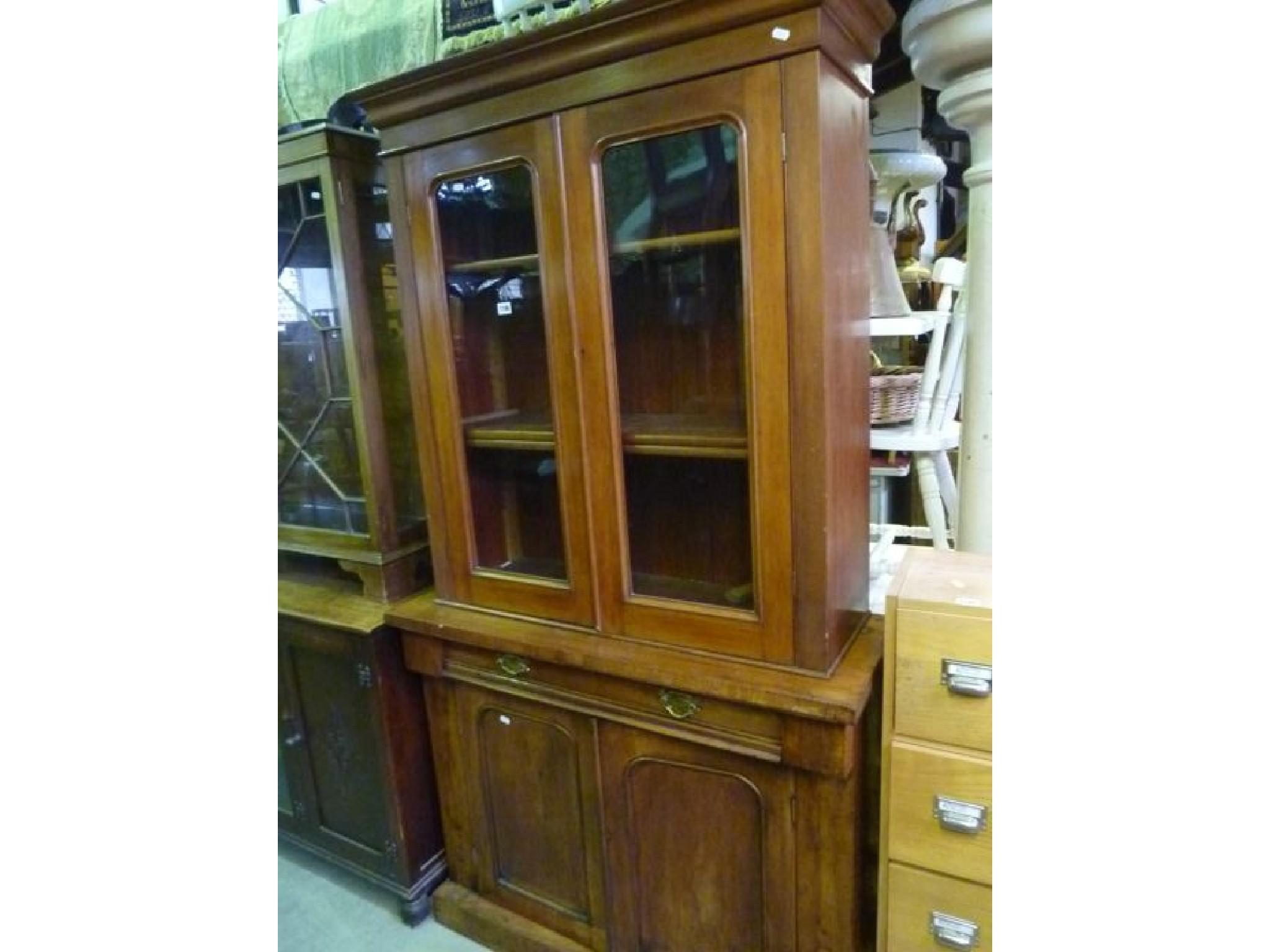 Appraisal: A Victorian mahogany bookcase enclosed by a pair of arched