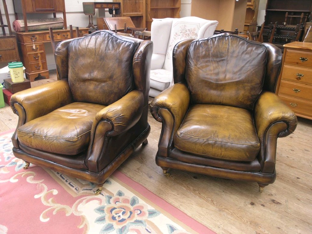 Appraisal: A pair of Thomas Lloyd leather wing armchairs traditional style