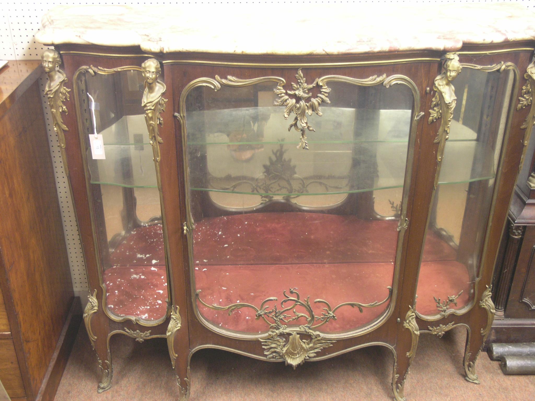 Appraisal: A large Louis XV-style mahogany display cabinet serpentine-shape with elaborate