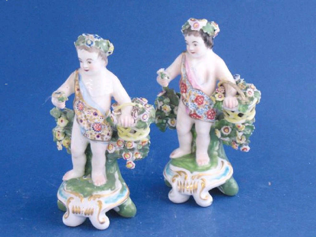 Appraisal: A PAIR OF DERBY CHERUB GARDENERS th century modelled holding