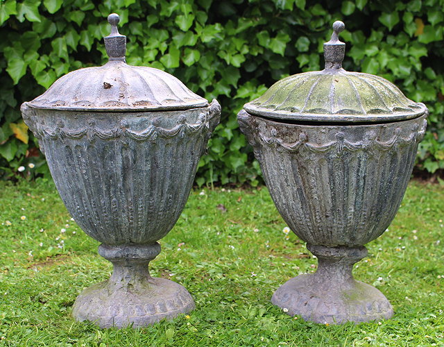 Appraisal: A PAIR OF LEAD ADAM STYLE FLUTED URNS AND COVERS