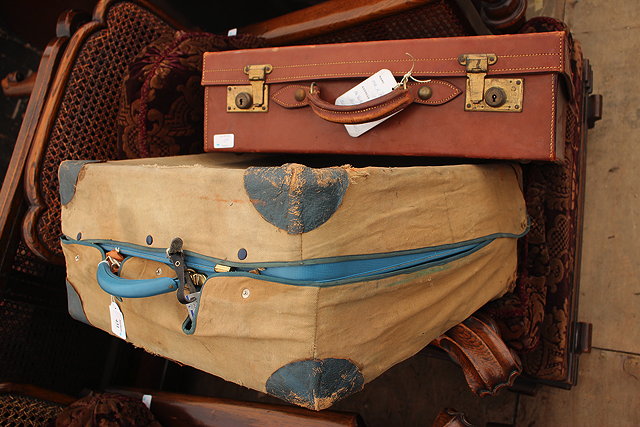 Appraisal: AN AMBER BLUE LEATHERETTE TRAVELLING SUITCASE with original canvas cover