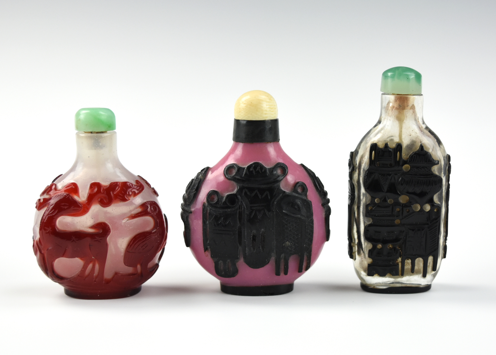 Appraisal: THREE CHINESE OVERLAY GLASSWARE SNUFF BOTTLES three Chinese glassware snuff