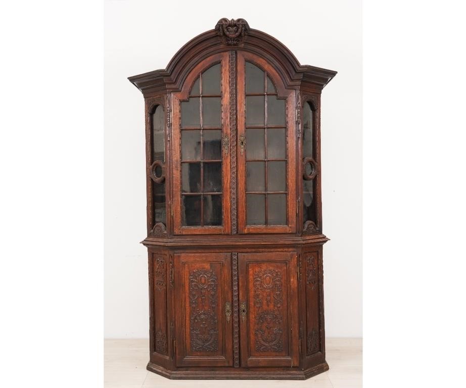 Appraisal: Continental oak two-piece cabinet with two arched glass doors decorated