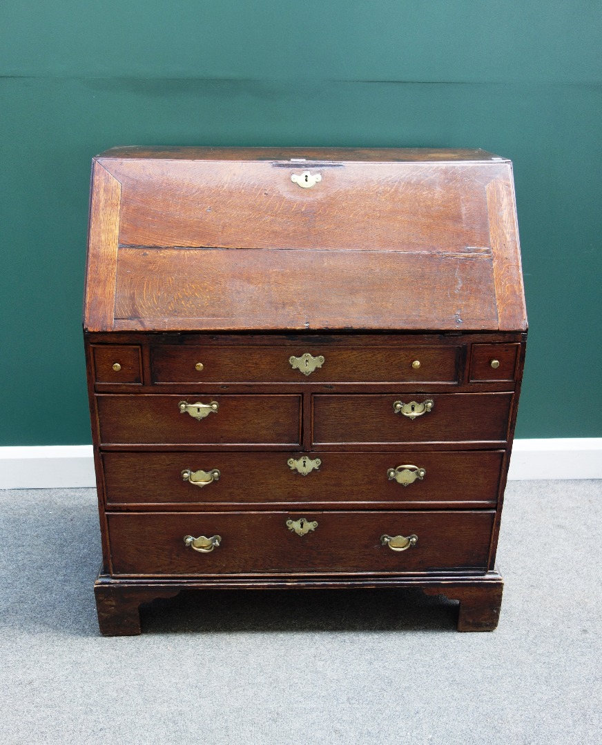 Appraisal: An th century oak bureau the fall enclosing a stepped