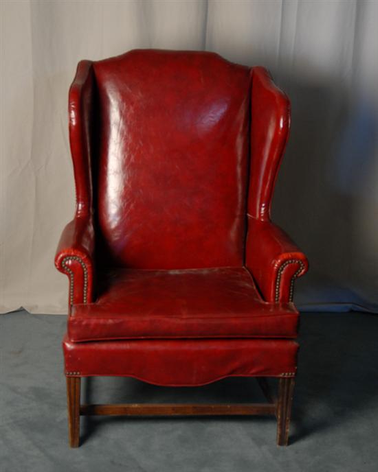 Appraisal: A Wingback Chair upholstered in faux red leather and with