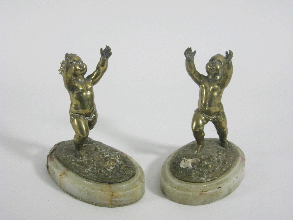 Appraisal: Pair of bronze Cherubs with outstretched arms on oval bases