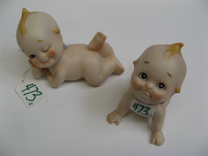 Appraisal: TWO KEWPIE BISQUE FIGURINES painted hair and features lying on